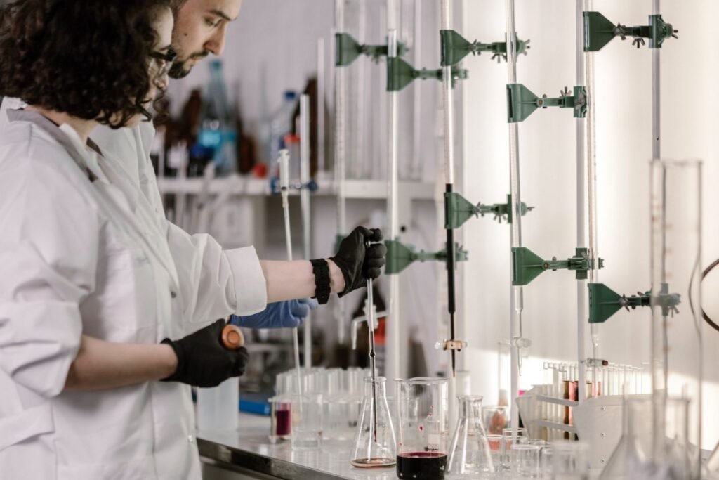 Scientists in lab coats work with test tubes in a modern laboratory.